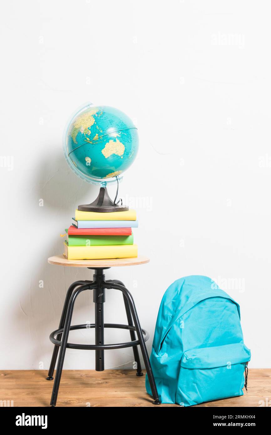 Globe books placed stool chair schoolbag Stock Photo