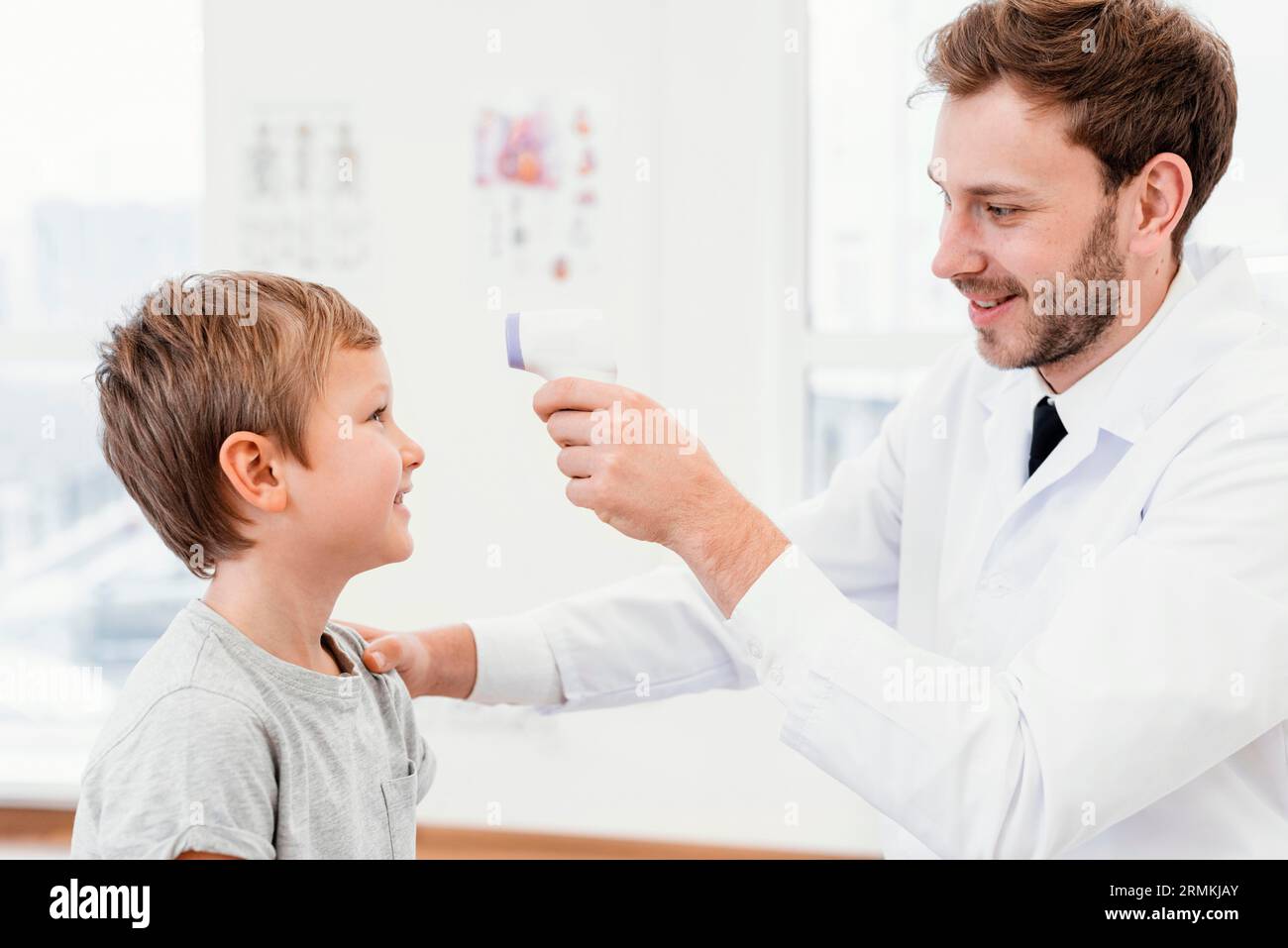 Medium shot doctor checking kid temperature Stock Photo