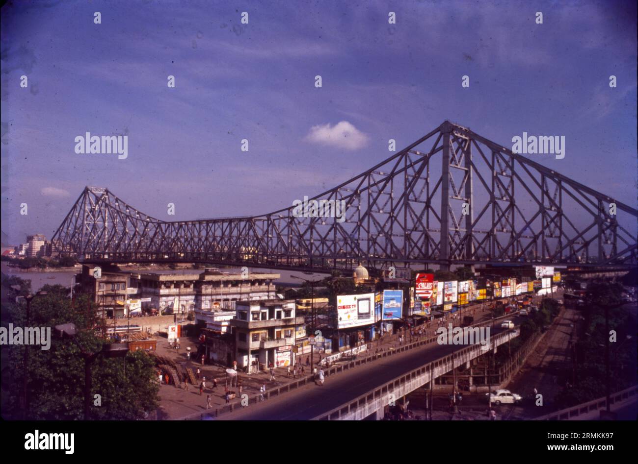 The Howrah Bridge is a balanced cantilever bridge over the Hooghly River in West Bengal, India. Commissioned in 1943, An iconic landmark in Kolkata, the Howrah Bridge is a huge steel bridge over the Hooghly River. It is considered to be one of the longest cantilever bridges in the world. Also known as Rabindra Setu, it connects Howrah and Kolkata. It carries 100,000 vehicles and countless pedestrians daily. Stock Photo