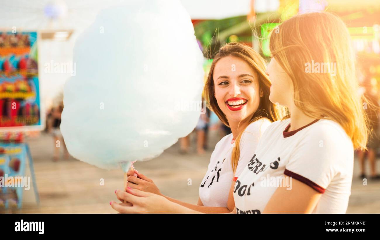 Two smiling female friends holding blue candy floss Stock Photo