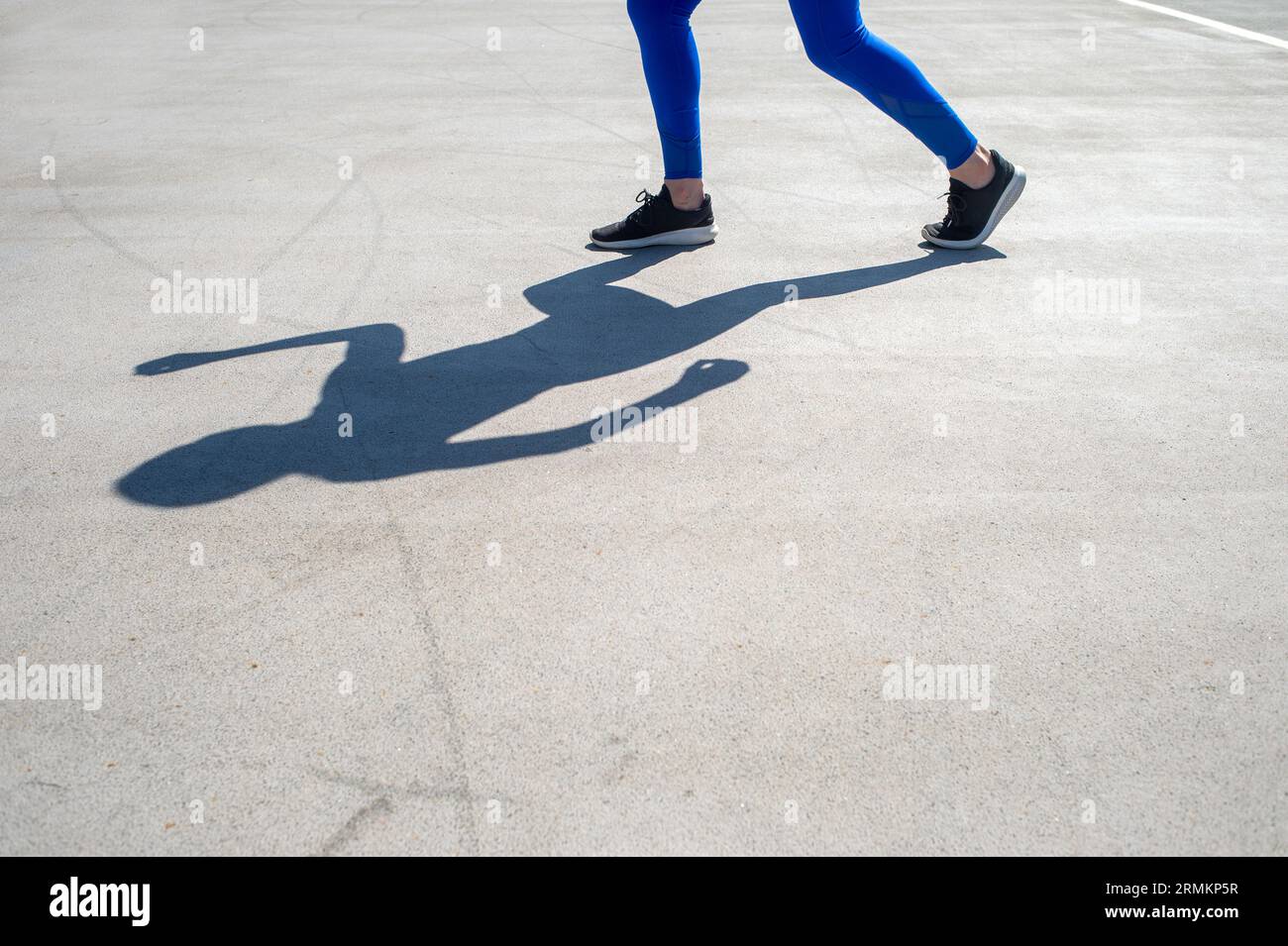 shadow of a woman athlete jogger in road Stock Photo