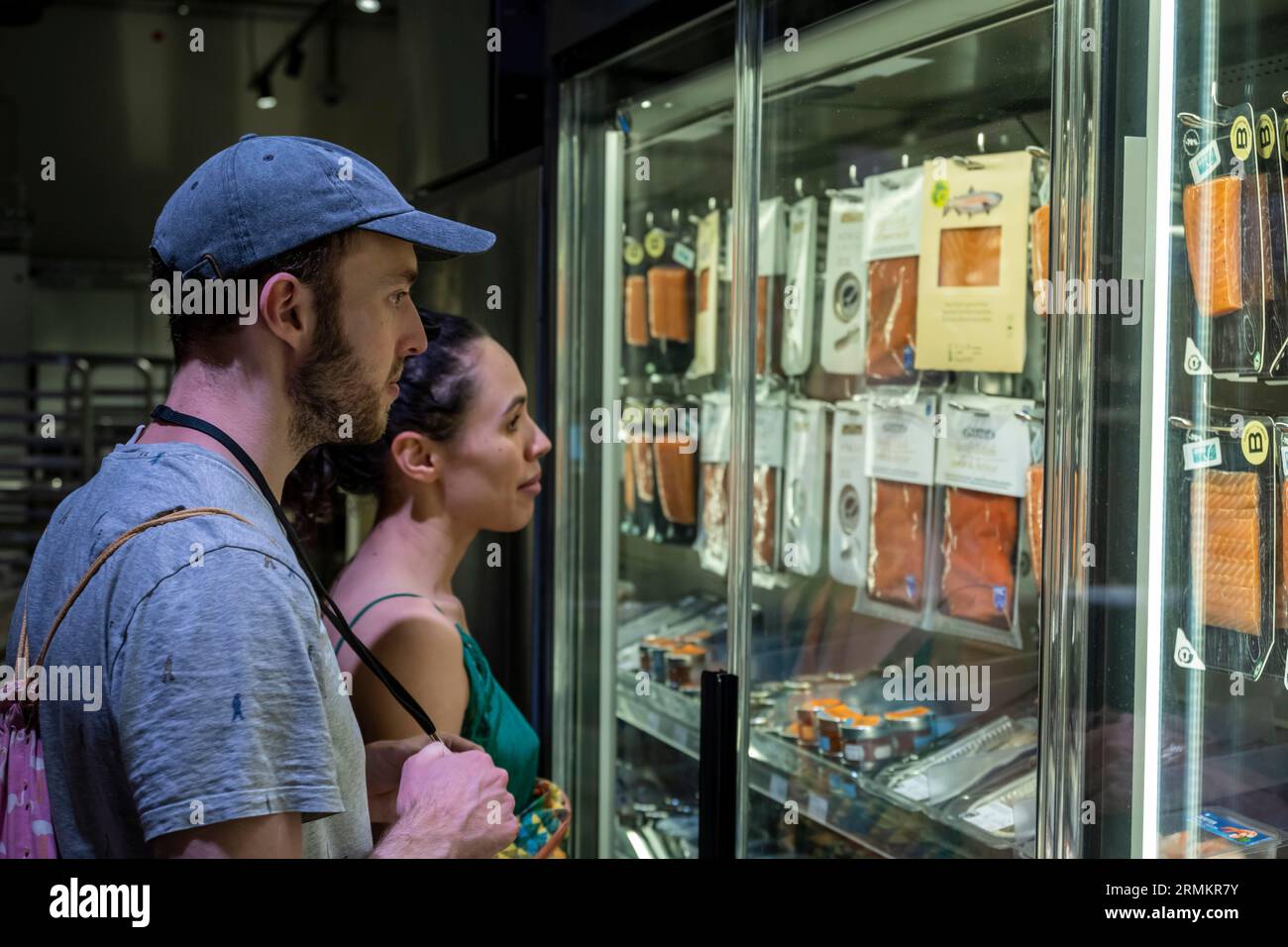 Two people looking for food in a supermarket, Switzerland Stock Photo