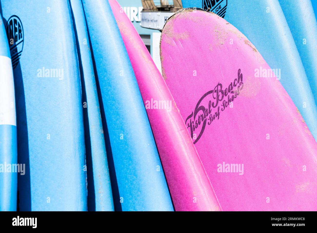 Colourful surfboards stacked and available to hire at the surf hire