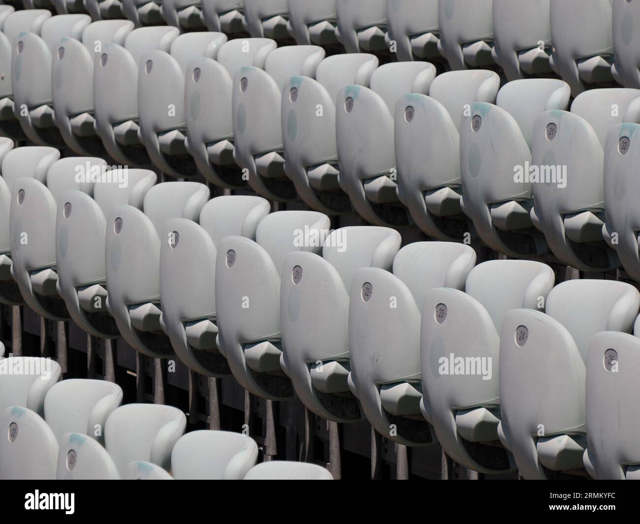 Rows of numbered empty plastic seats at an open-air amphitheater many audience open theater seats Stock Photo