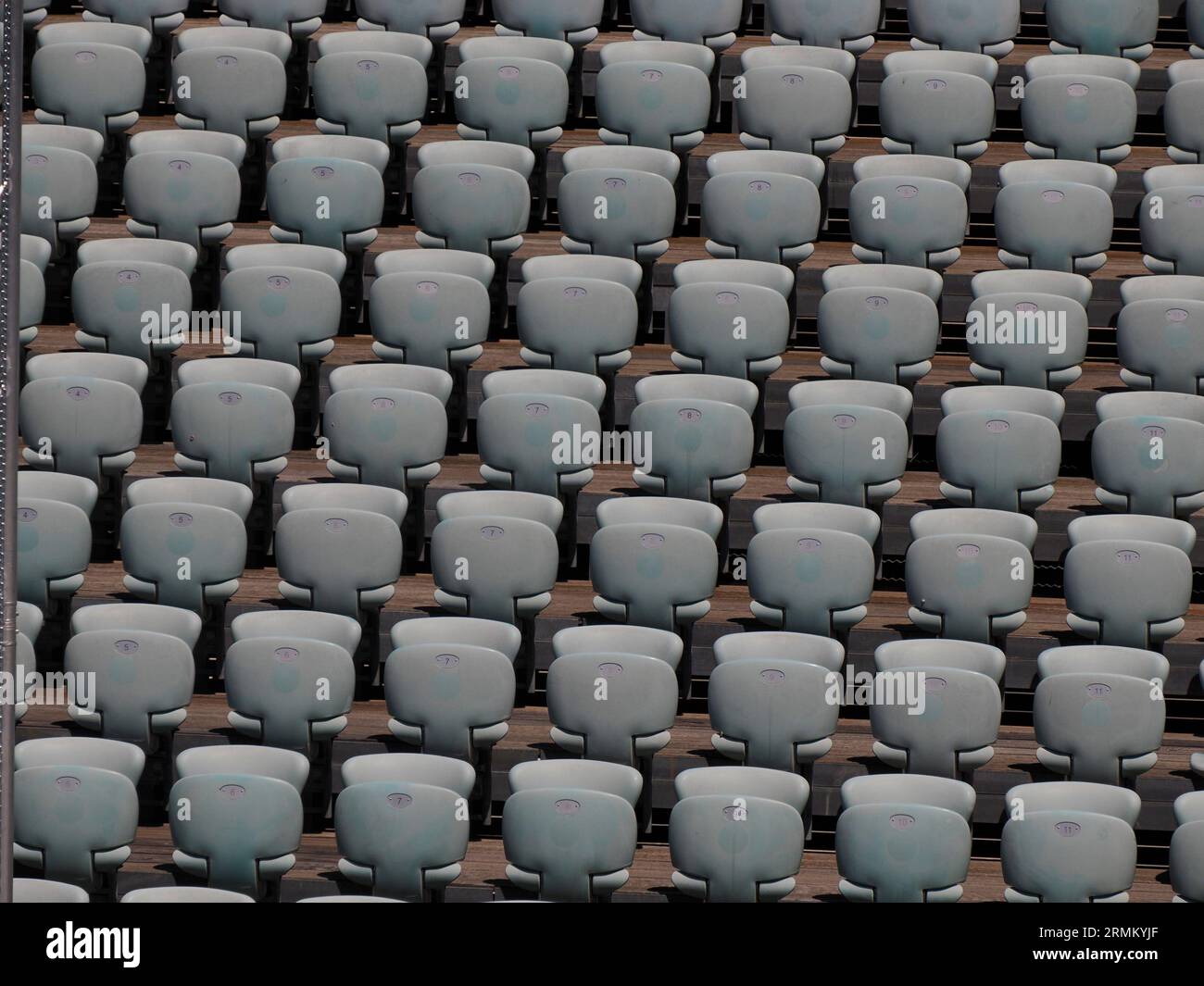 Rows of numbered empty plastic seats at an open-air amphitheater many audience open theater seats Stock Photo