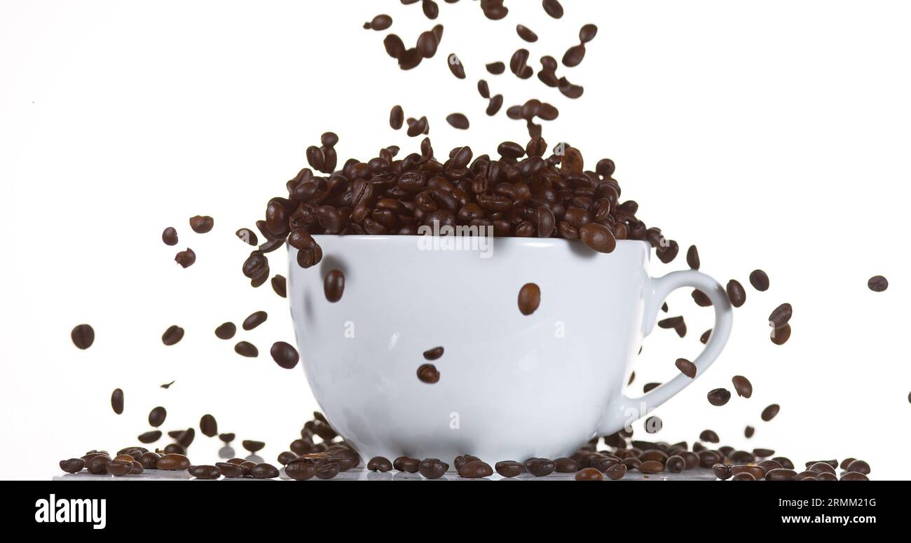 Coffee Beans Falling into a Cup against White Background Stock Photo ...