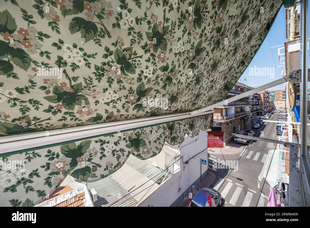 Views of the street from a window with an extensible awning of printed fabric Stock Photo