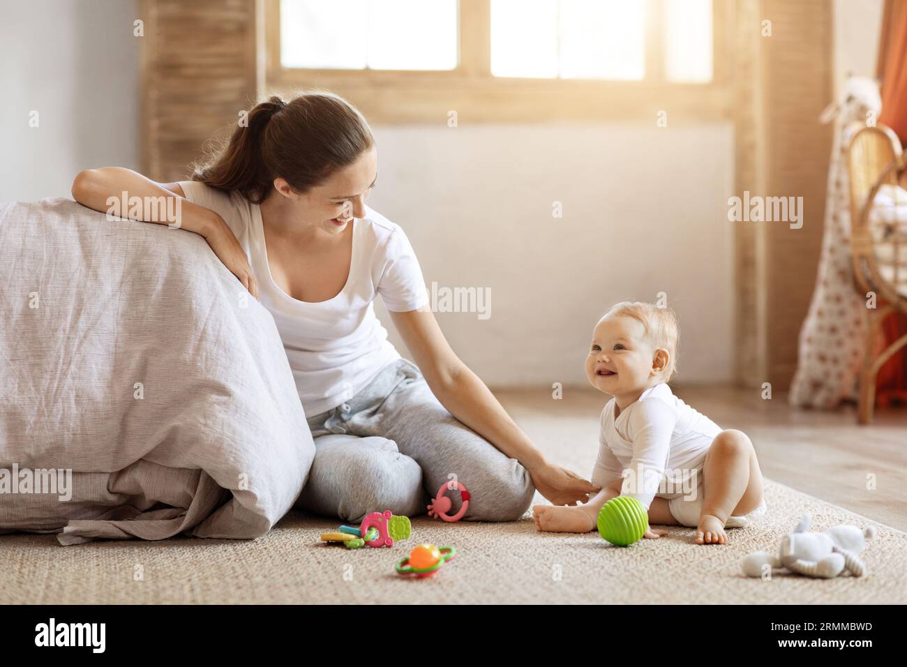 Happy mom sitting on floor play with baby at home Stock Photo - Alamy