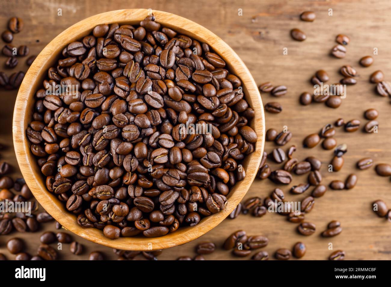 bowl full of organic coffee beans on old wooden table Stock Photo