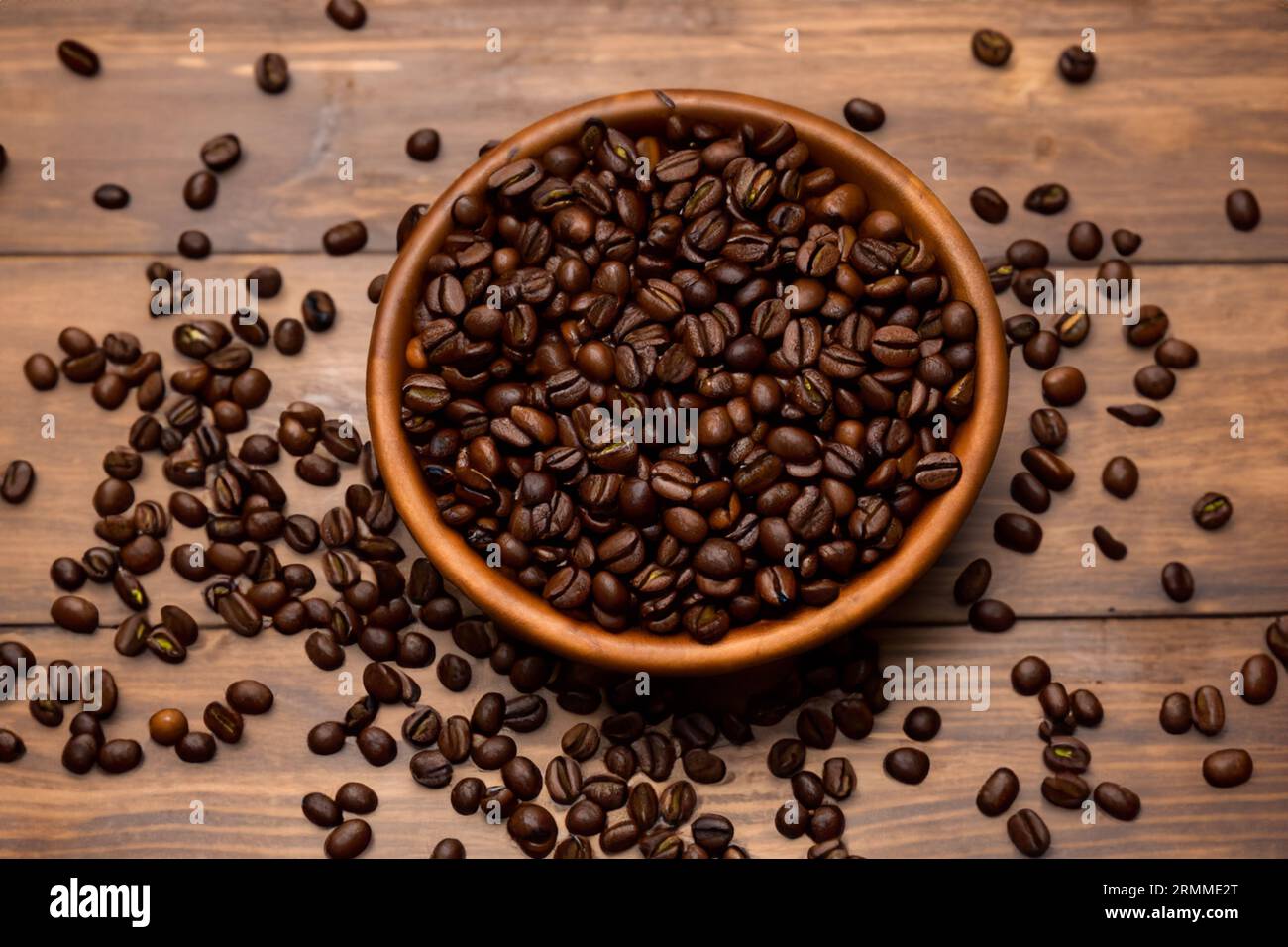 bowl full of organic coffee beans on old wooden table Stock Photo