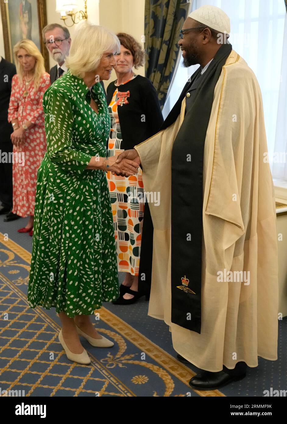 Queen Camilla meets Squadron Leader Imam Ali Omar at the Royal Air Force Club in Piccadilly, central London, where she unveiled a portrait of Special Operations Executive (SOE) Operative, Noor-un-Nisa Inayat Khan GC, and formally announced the naming of a room in her honour. Picture date: Tuesday August 29, 2023. Stock Photo