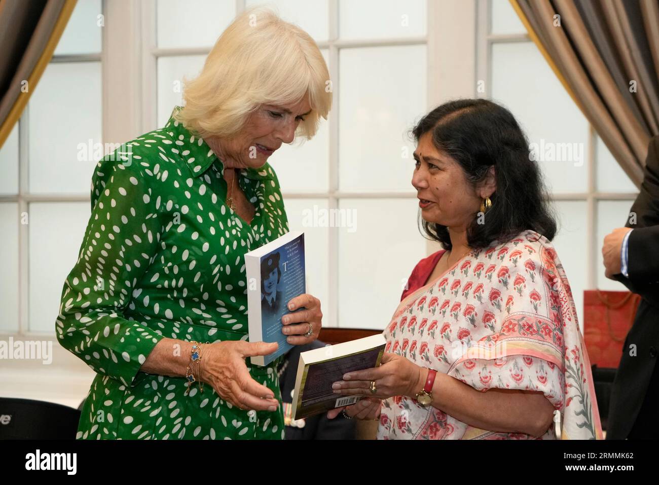 Queen Camilla is presented with a book called The Spy Princess - the Life of Noor Inyat Khan, by author Shrabani Basu (right) at the Royal Air Force Club in Piccadilly, central London, where she unveiled a portrait of Special Operations Executive (SOE) Operative, Noor-un-Nisa Inayat Khan GC, and formally announced the naming of a room in her honour. Picture date: Tuesday August 29, 2023. Stock Photo