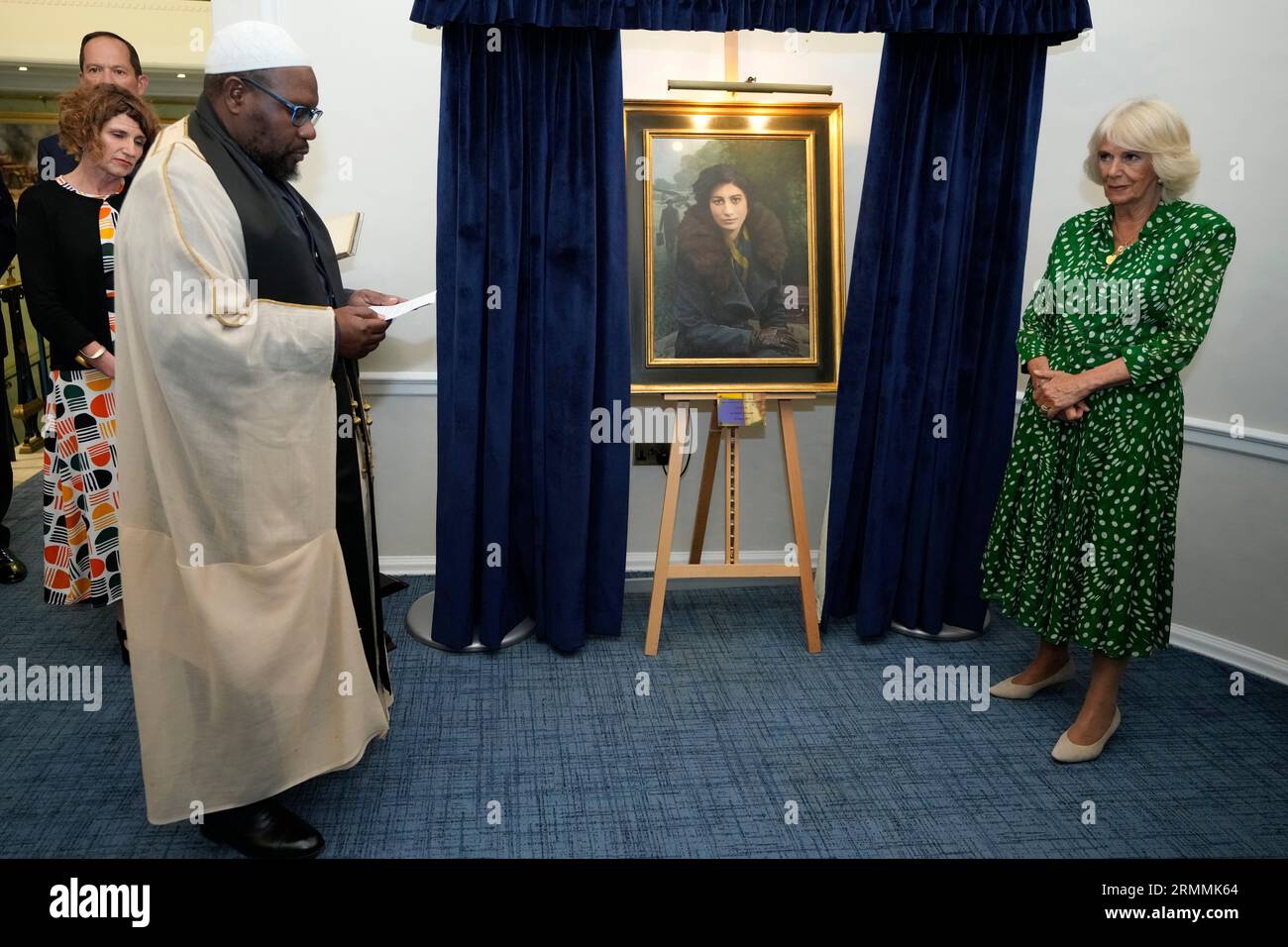 Queen Camilla listens to Squadron Leader Imam Ali Omar read a blessing at the Royal Air Force Club in Piccadilly, central London, where she unveiled a portrait of Special Operations Executive (SOE) Operative, Noor-un-Nisa Inayat Khan GC, and formally announced the naming of a room in her honour. Picture date: Tuesday August 29, 2023. Stock Photo