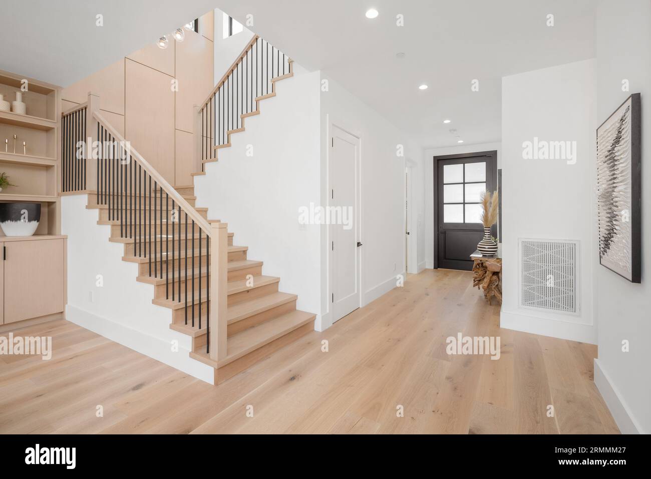 An inviting open-plan interior design with a white staircase leading to ...