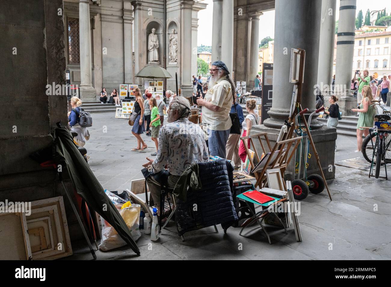 Artists sit around to paint and sell their work to visiting tourists at the Loggiato, a semi-enclosed courtyard, part of the Galleria degli Uffizi ( U Stock Photo