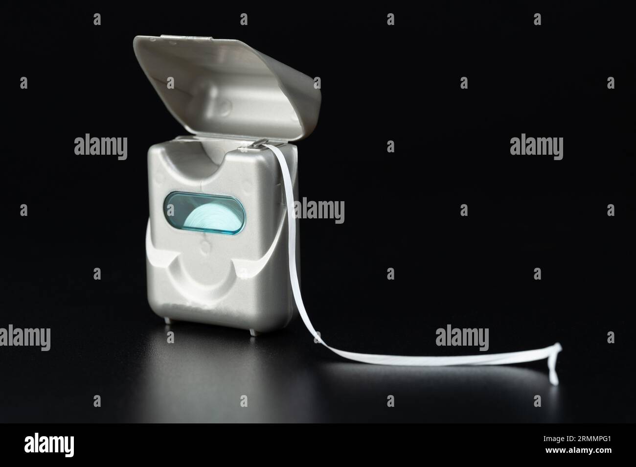 Dental floss box with line string isolated on black studio background