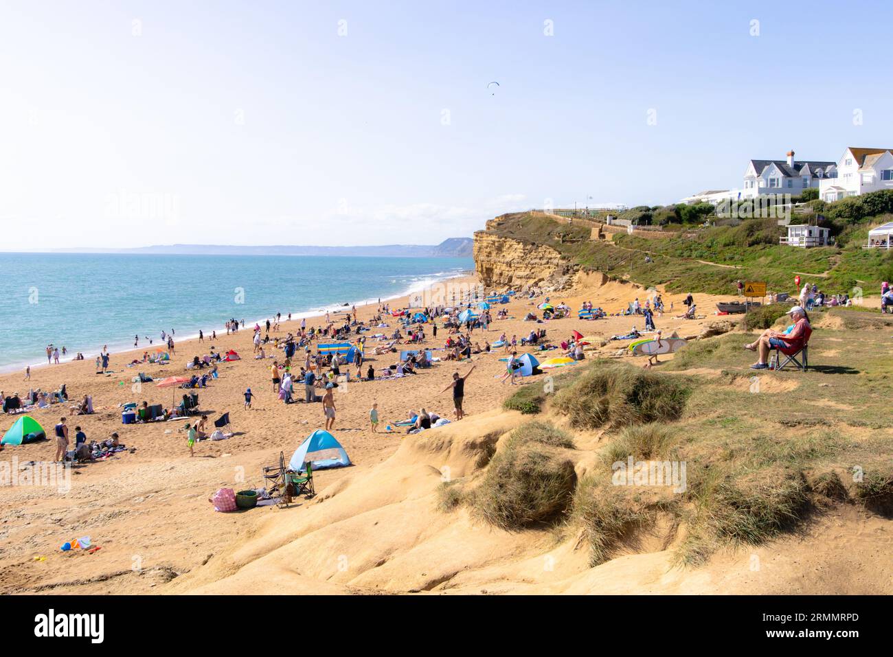 Uk Beach summer sunshine - People sunbathing in August on Hive Bay Beach, Dorset UK, part of the Jurassic coast Stock Photo