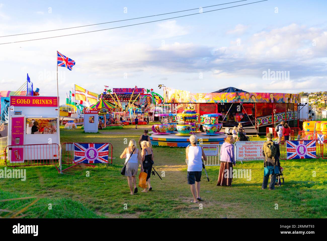 UK fairground; people heading for the funfair, West Bay fairground in summer, West Bay Dorset UK Stock Photo