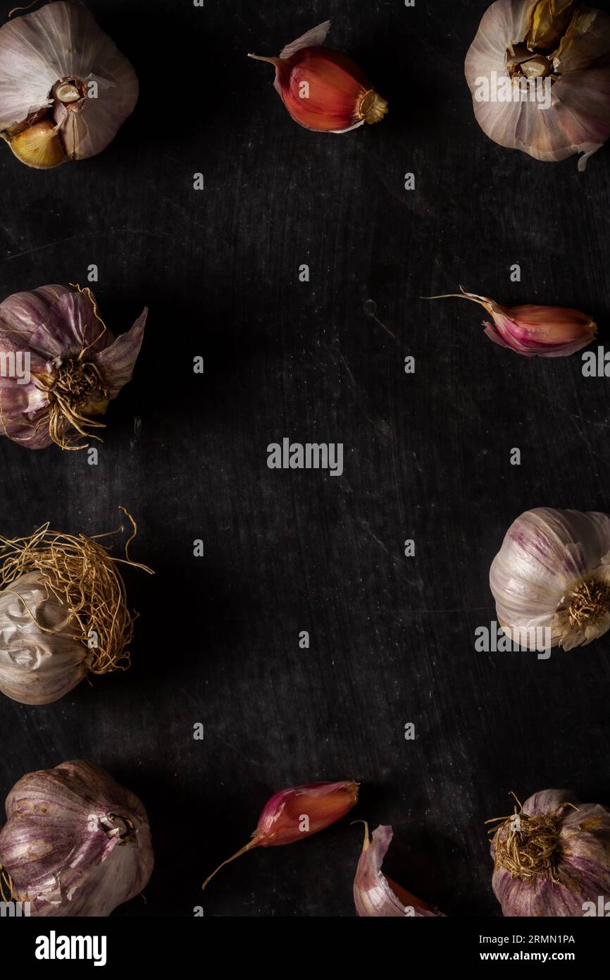 Fresh garlic bulbs and cloves grouped on black background. Flat lay ...