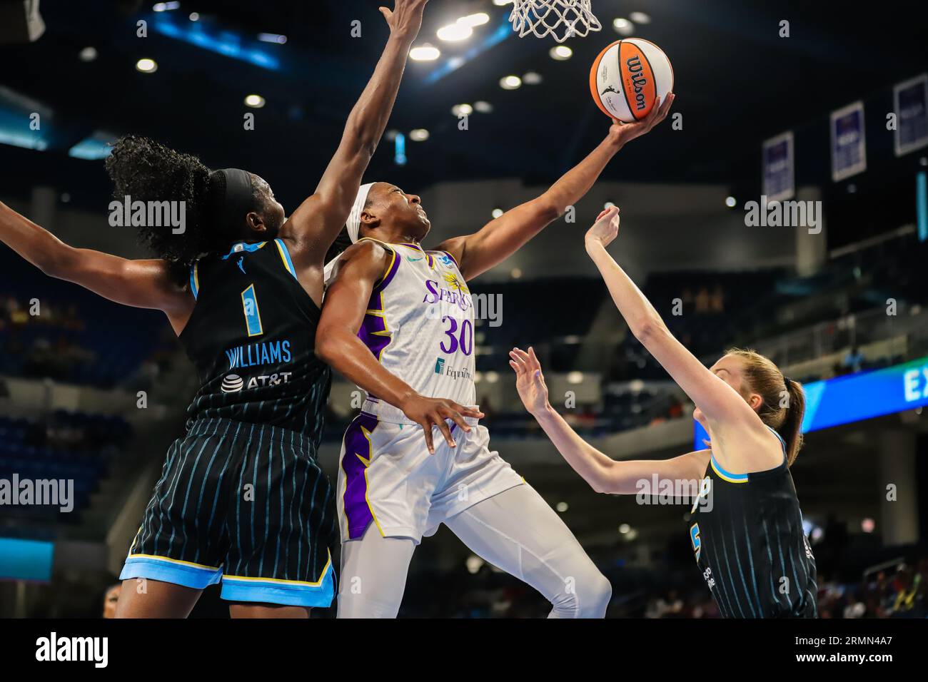 Nneka Ogwumike makes a reverse layup over two Chicago Sky defenders in Chicago, IL at Wintrust Arena. Stock Photo
