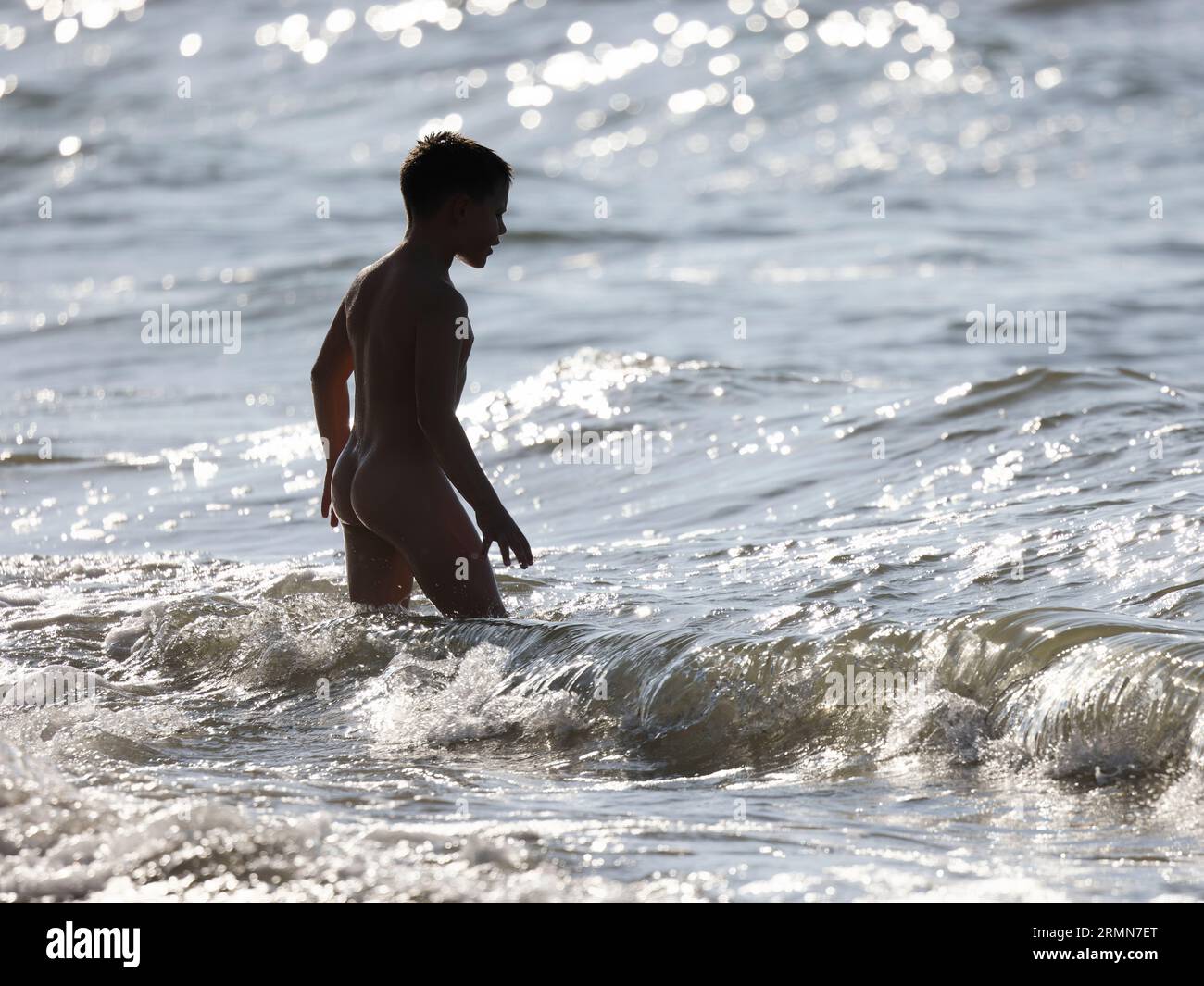 young naturiste Naked young boy entering to sea , in sea waves Stock Photo - Alamy