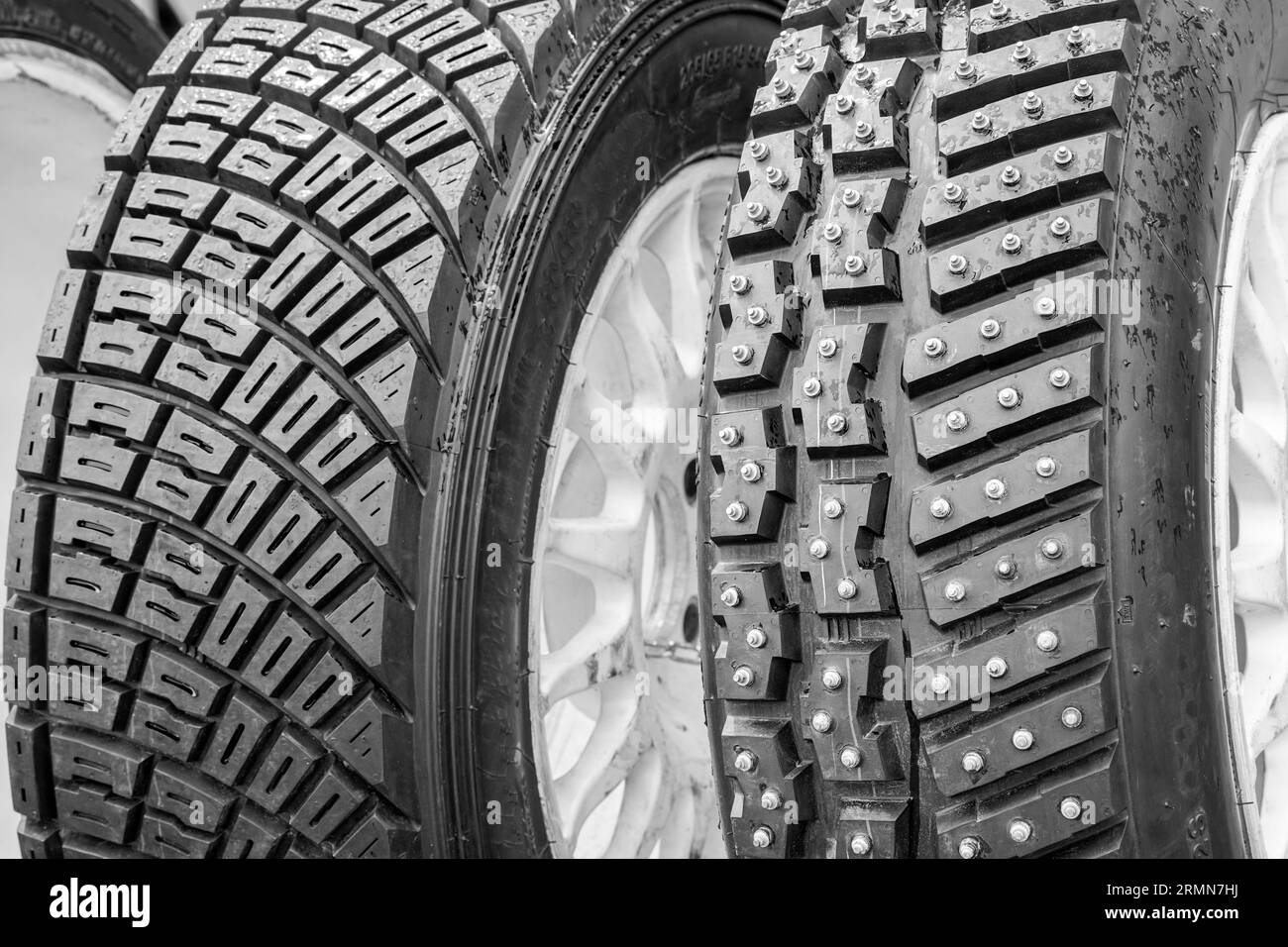 Two types of modern rally tires, studded winter snow and ice tire with big studs and asymmetric