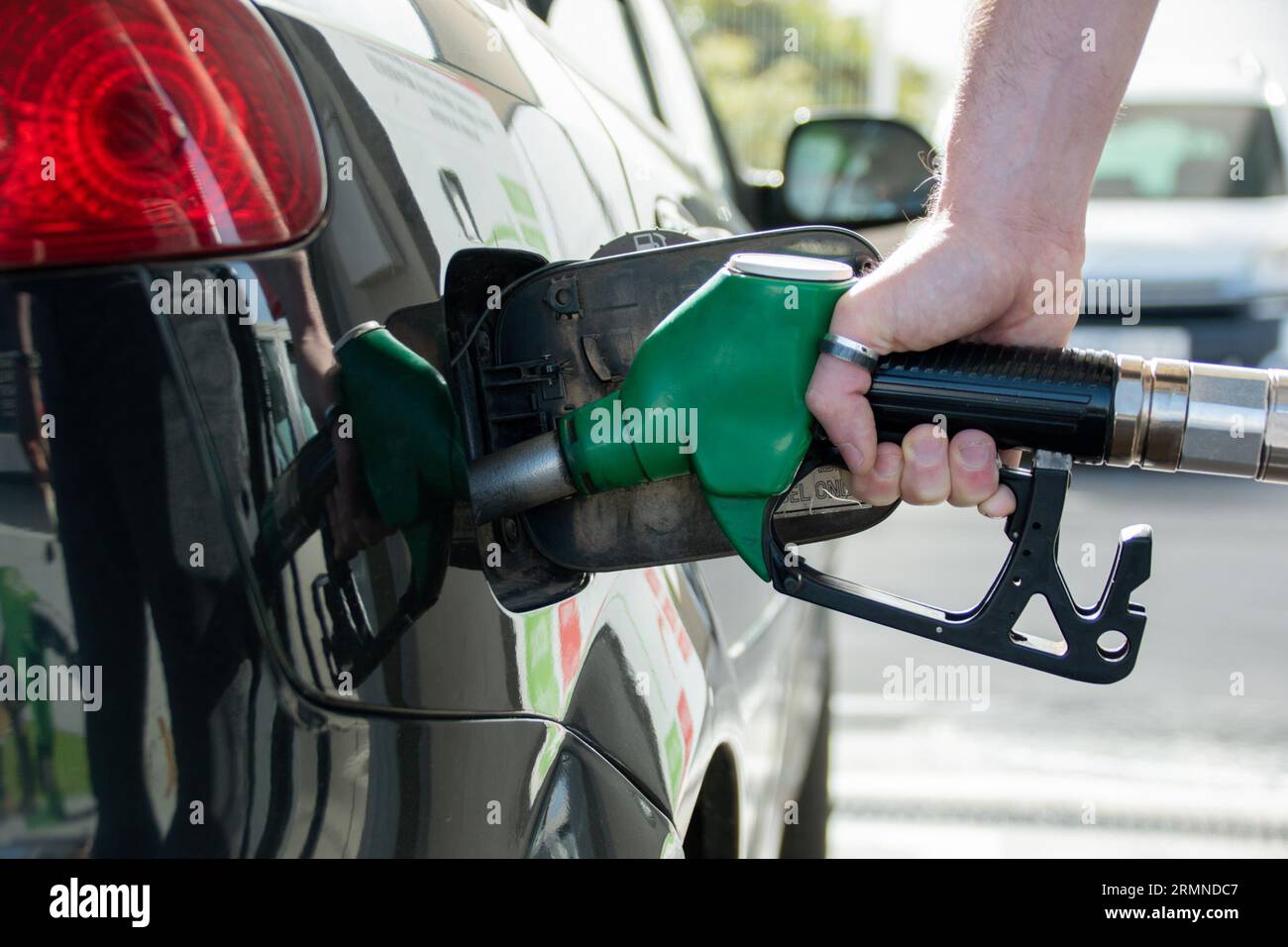 Close-up of the hand of a Caucasian man refueling his car with unleaded fuel Stock Photo