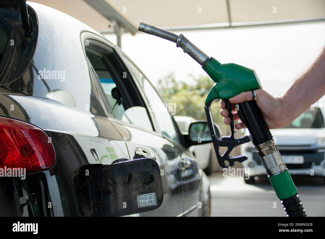 Closeup of the hand of a caucasian man holding up the petrol pump before refueling Stock Photo