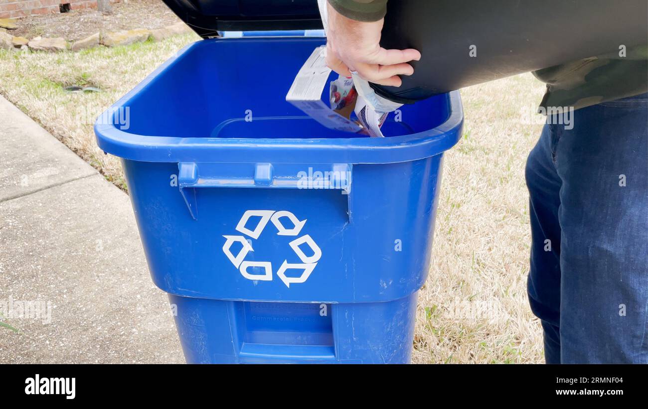 Man taking out recycling to the bin. Stock Photo