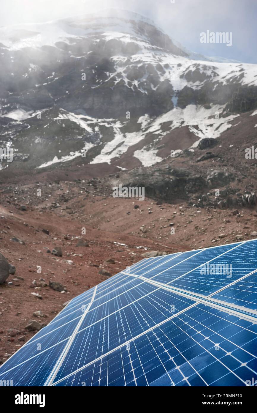 Close up photo of solar panels with Chimborazo volcano in background, selective focus, Ecuador. Stock Photo