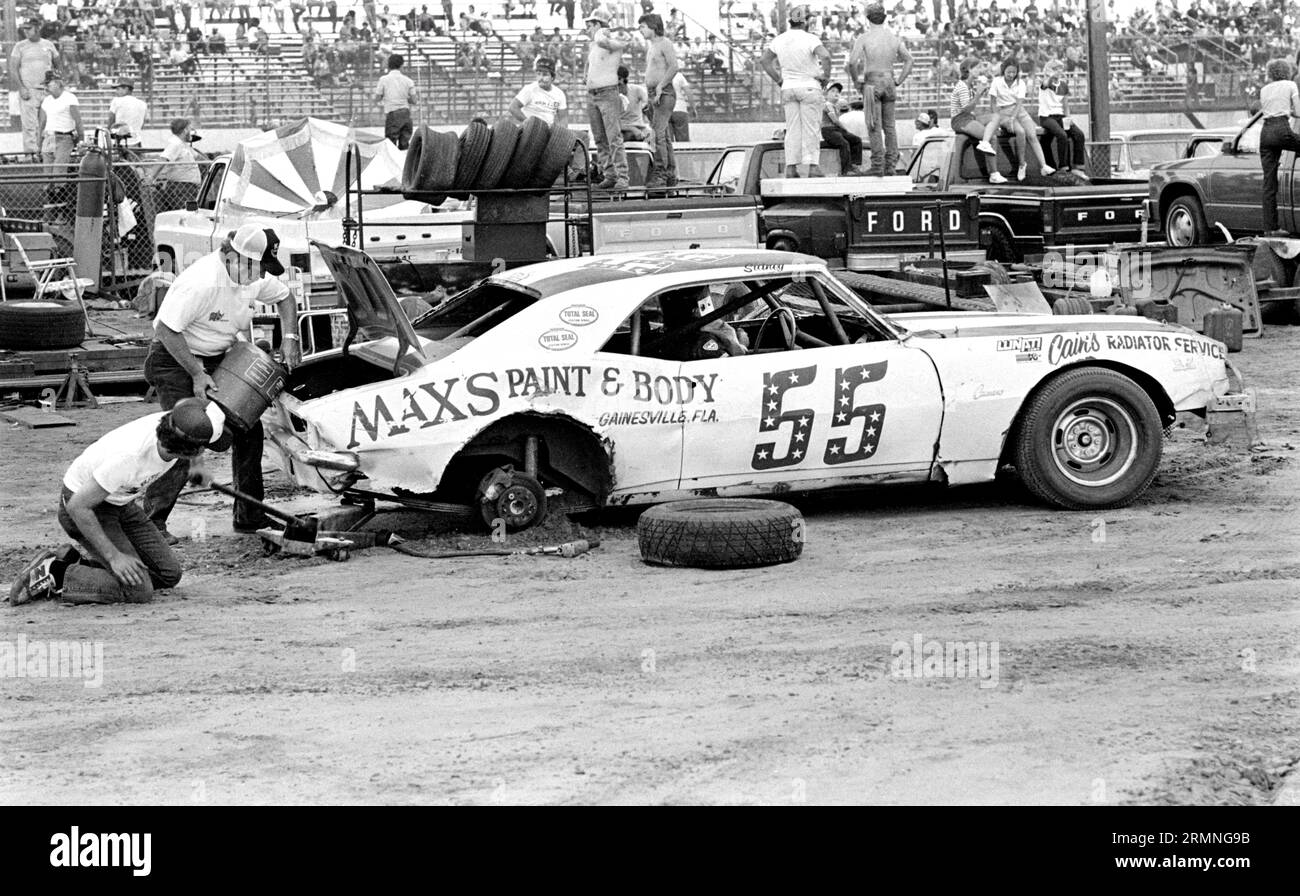 Weekend amateur stock car racing crews work on their cars during a pit