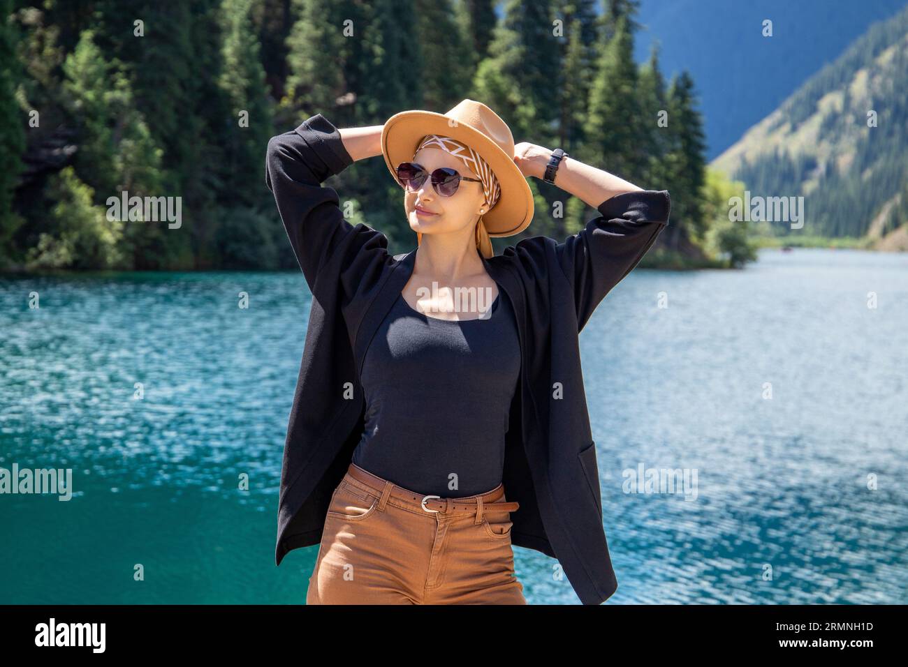 Happy woman on Kolsay mountain lake in Kolsai Koldery gorge, nature of Kazakhstan National Park Stock Photo