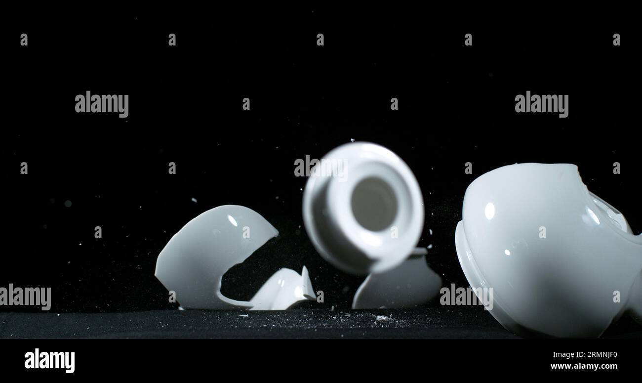 TeaPot falling and exploding on Black Background Stock Photo Alamy
