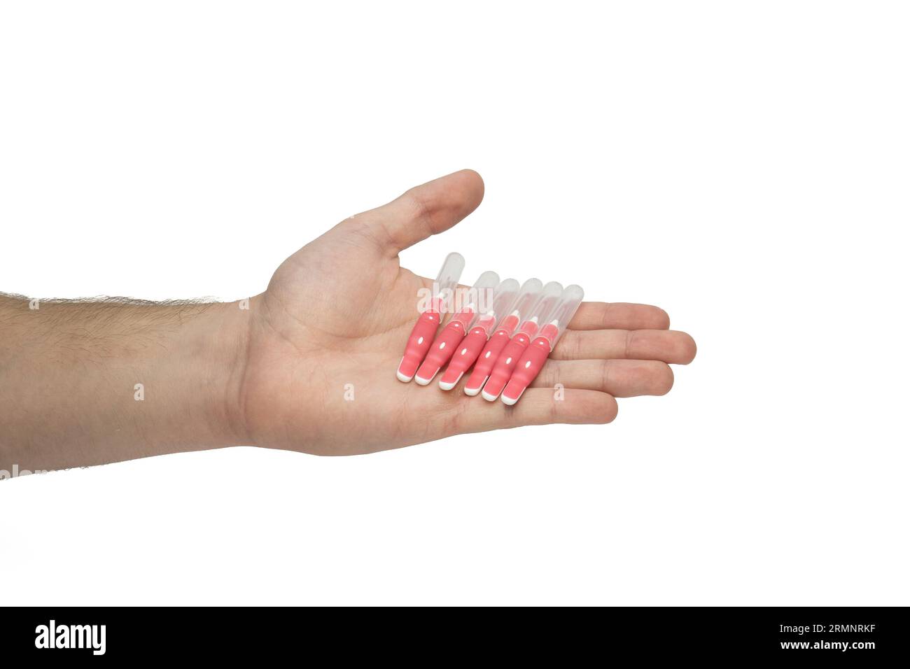 Male hand holding interdental brush sticks, offering dental brushes