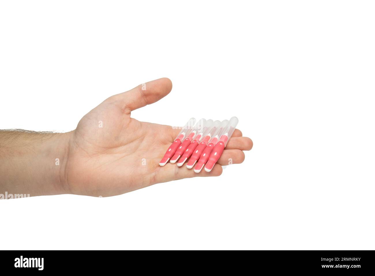Male hand holding interdental brush sticks, offering dental brushes