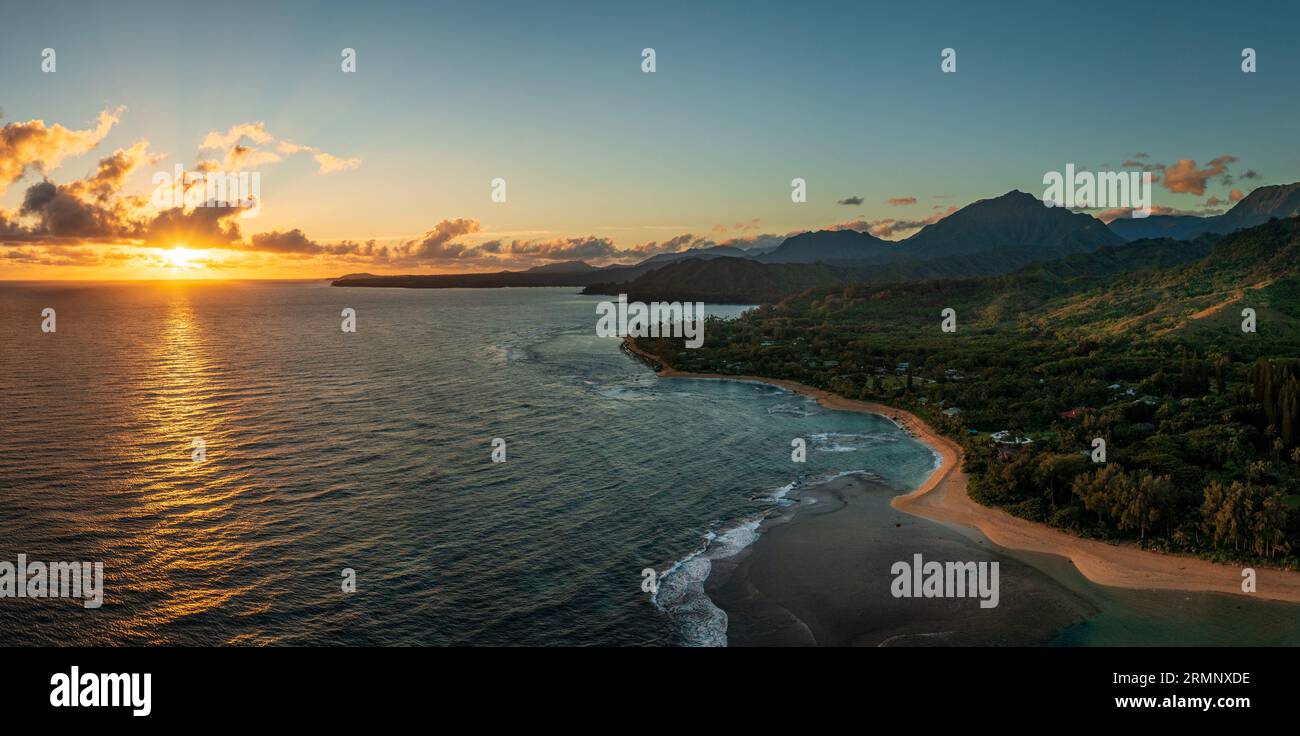 Dramatically wide panorama looking east from Tunnels Beach on Kauai towards the rising sun and