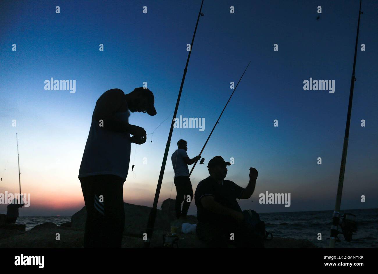 https://c8.alamy.com/comp/2RMNYRK/palestinian-men-use-fishing-rods-to-catch-fish-during-sunset-on-the-seashore-in-the-northern-gaza-strip-2RMNYRK.jpg