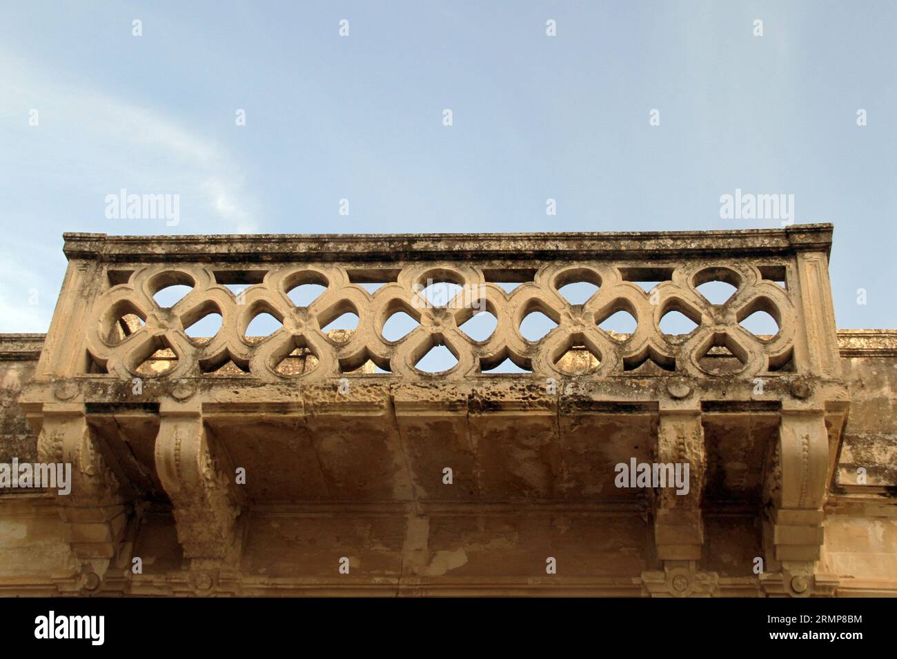Old stone decorated balcony with corbels in Lequile, Italy Stock Photo