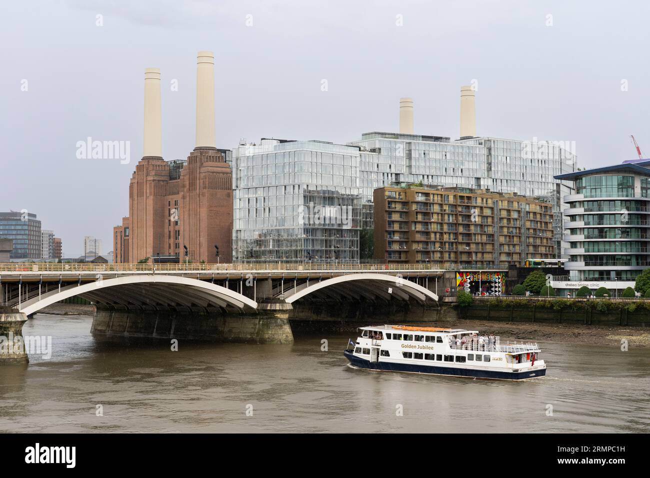 The Golden Jubilee party boat passing under the Grosvenor Railway Bridge with the iconic Battersea Power Station redevelopment behind. London, UK Stock Photo