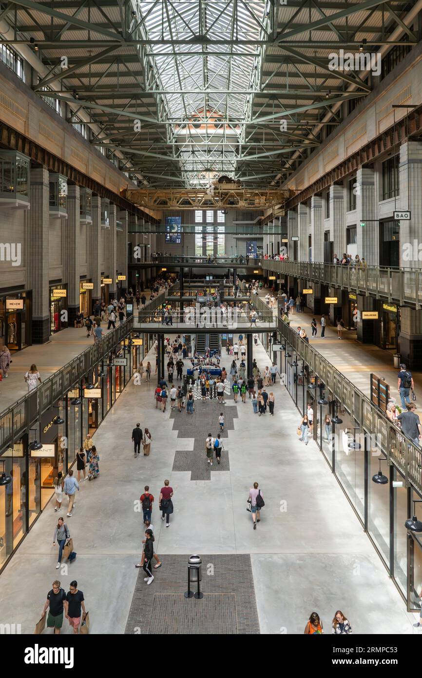 Turbine Hall A of the redeveloped & Grade II* listed Battersea Power Station with many visitors and shoppers filling the shopping centre. London Stock Photo