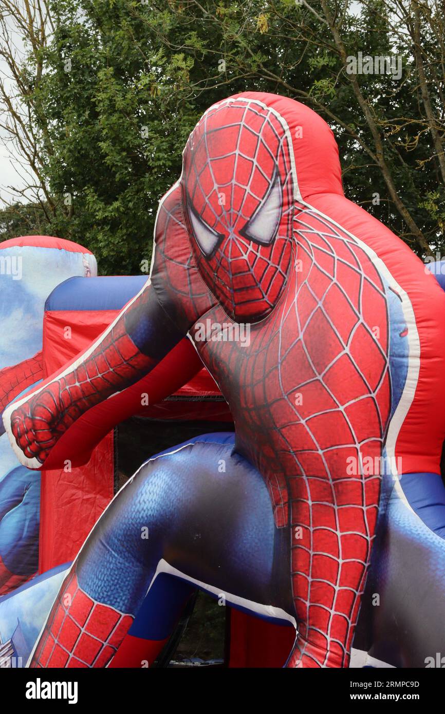 Larger than life super hero Spiderman featured on the front wall of a themed bouncy castle in a childrens play area at a local food show, August 2023. Stock Photo