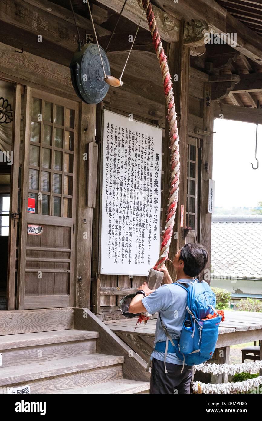 Japan, Kyushu. Makiodo Temple, Ringing the Temple Bell, or Gong. Stock Photo