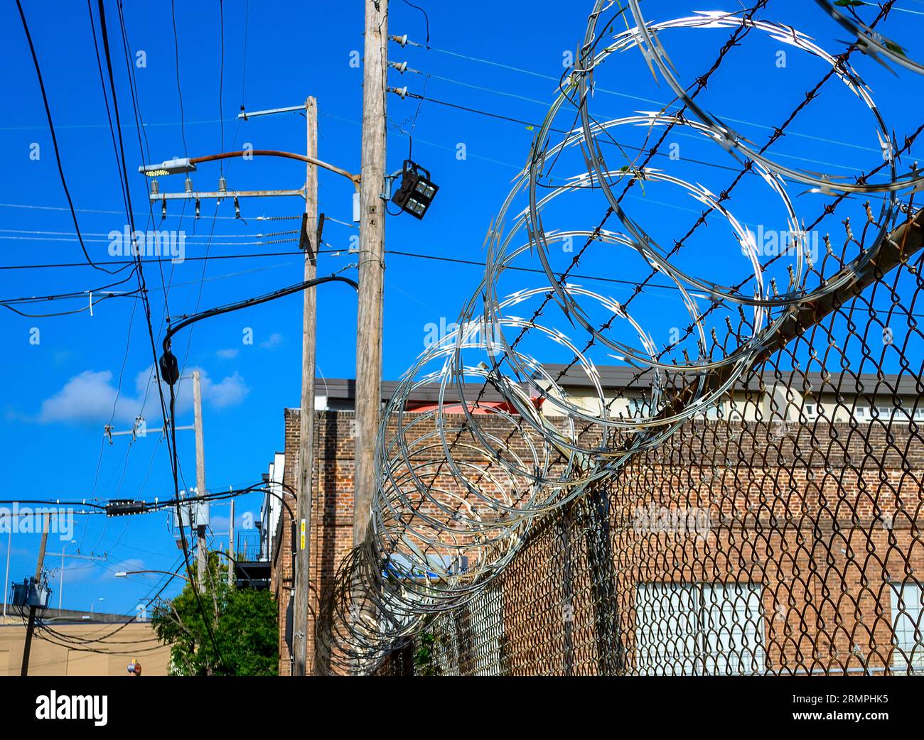 NEW ORLEANS, LA, USA - AUGUST 22, 2023: Razor concertina wire on a fence protecting a business in an urban setting Stock Photo