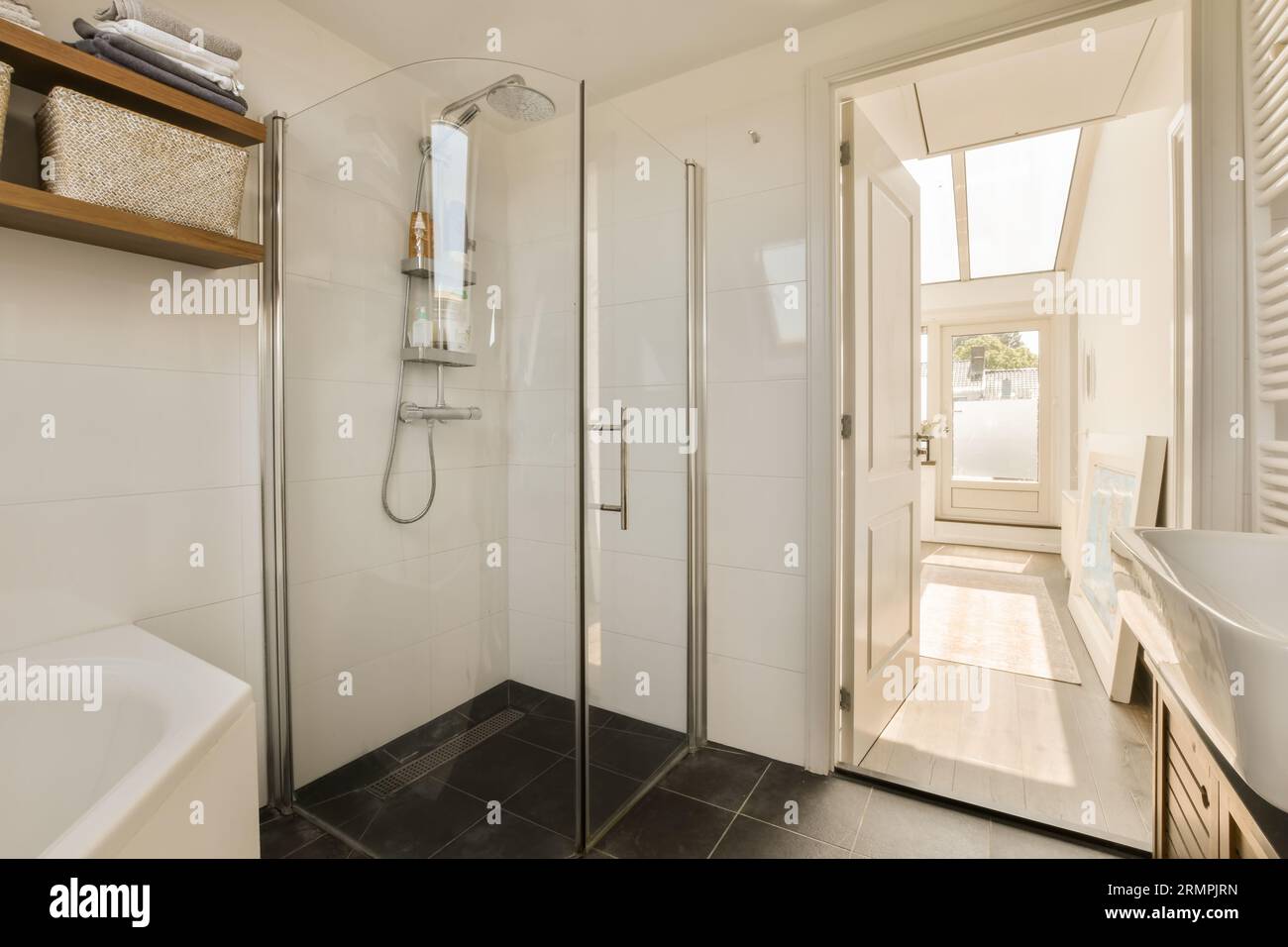 a modern bathroom with black tile flooring and white walls, there is a ...