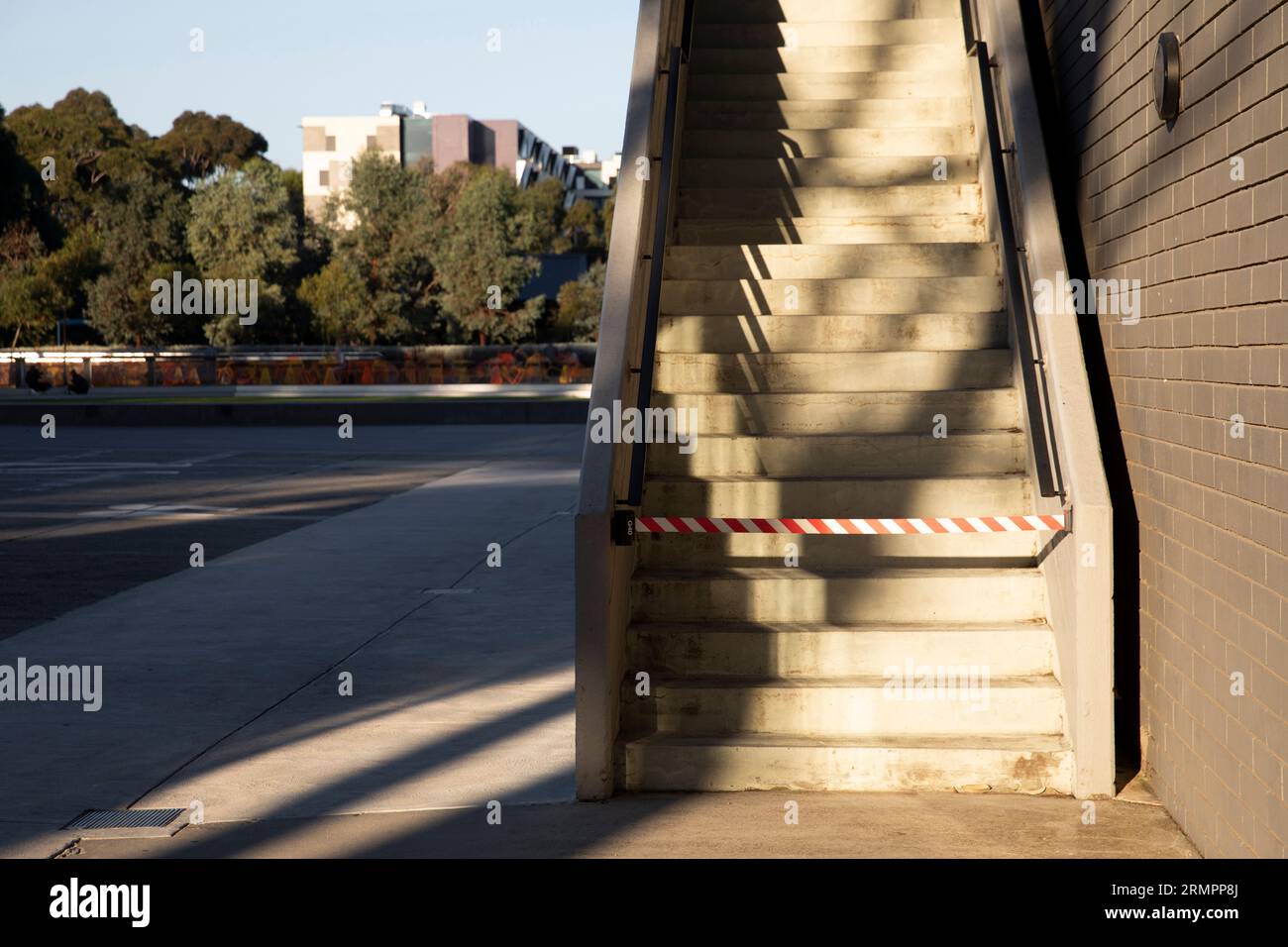 Exterior staircases are blocked off with hazard warning tape, restricting access for safety