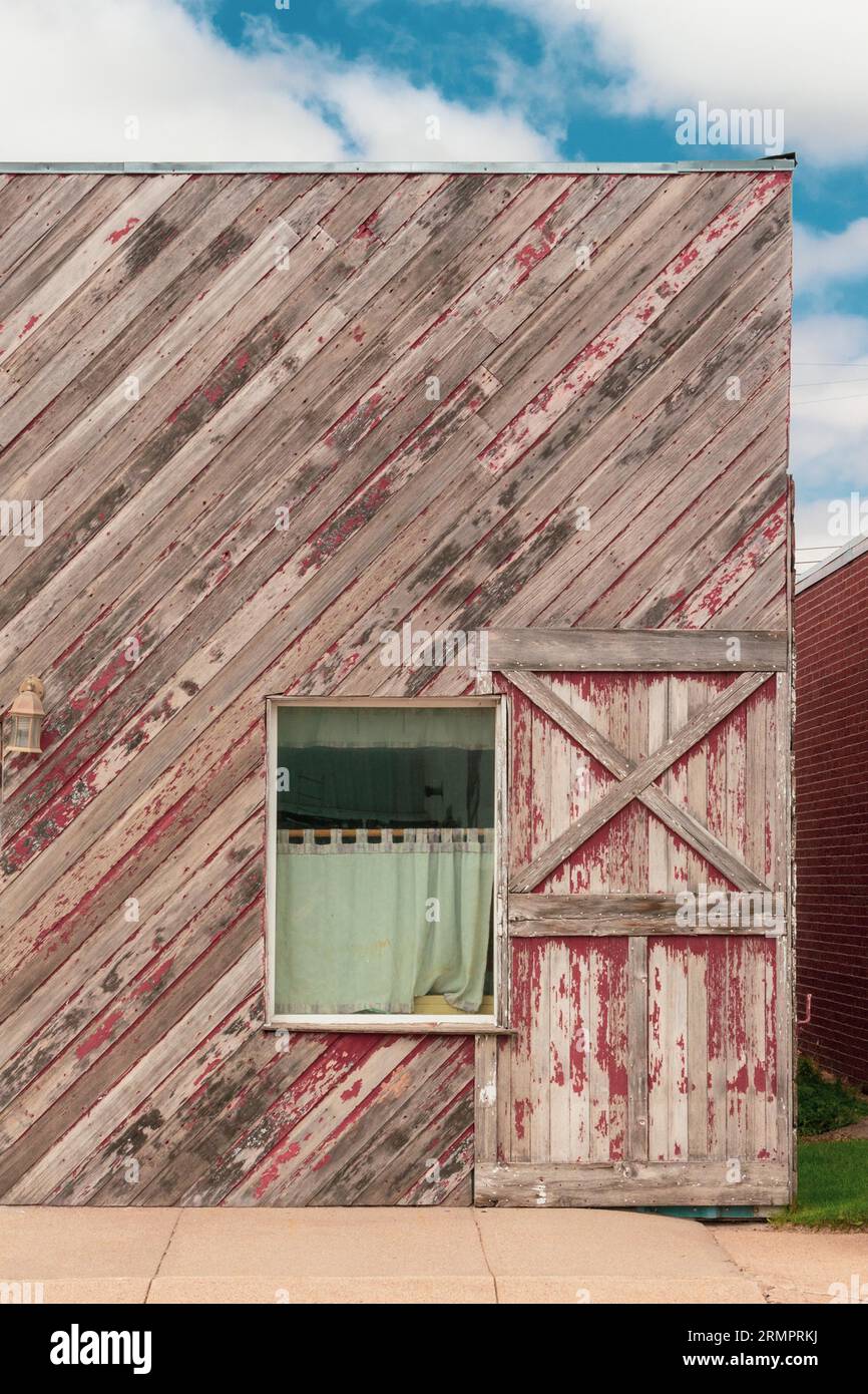 A rustic wooden barn door with a green fabric curtain draped over the