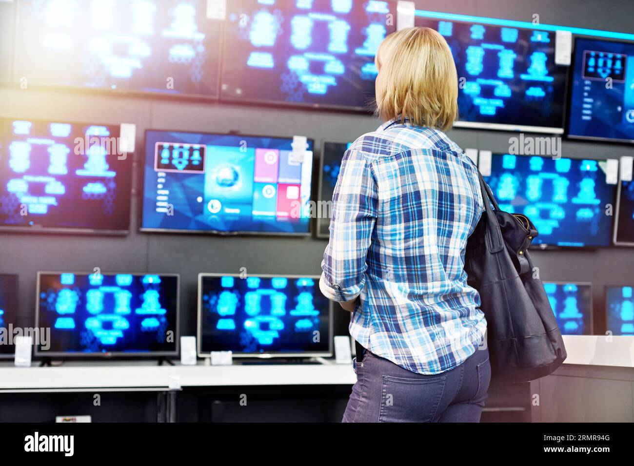 Woman looks at LCD TVs in supermarket Stock Photo