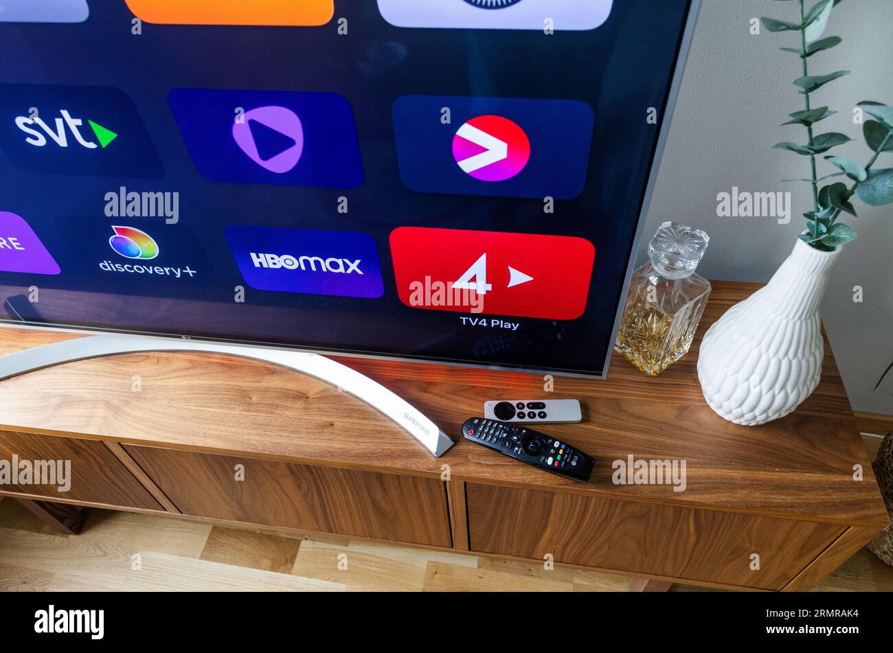 Remote controls in front of a tv screen in a home Stock Photo Alamy