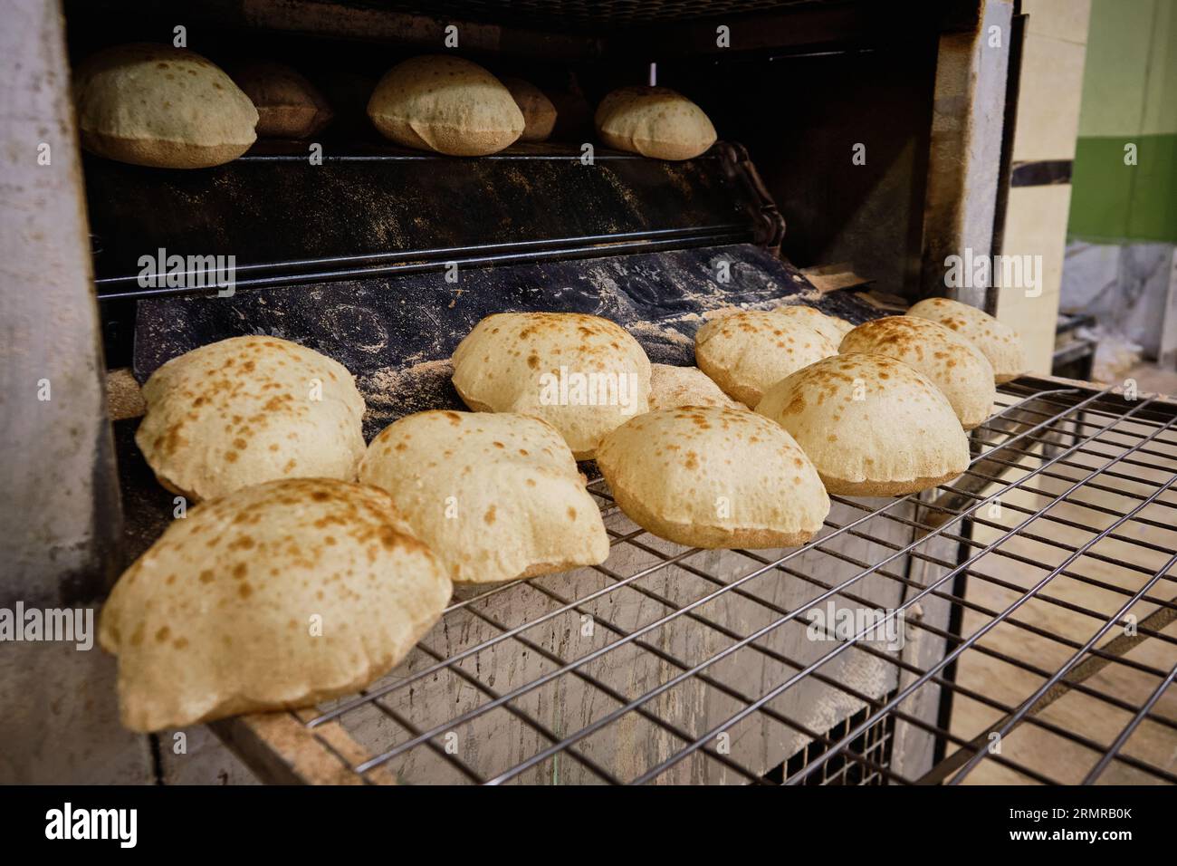 Baking traditional egyptian flatbread aish baladi. Freshly baked pita bread from oven