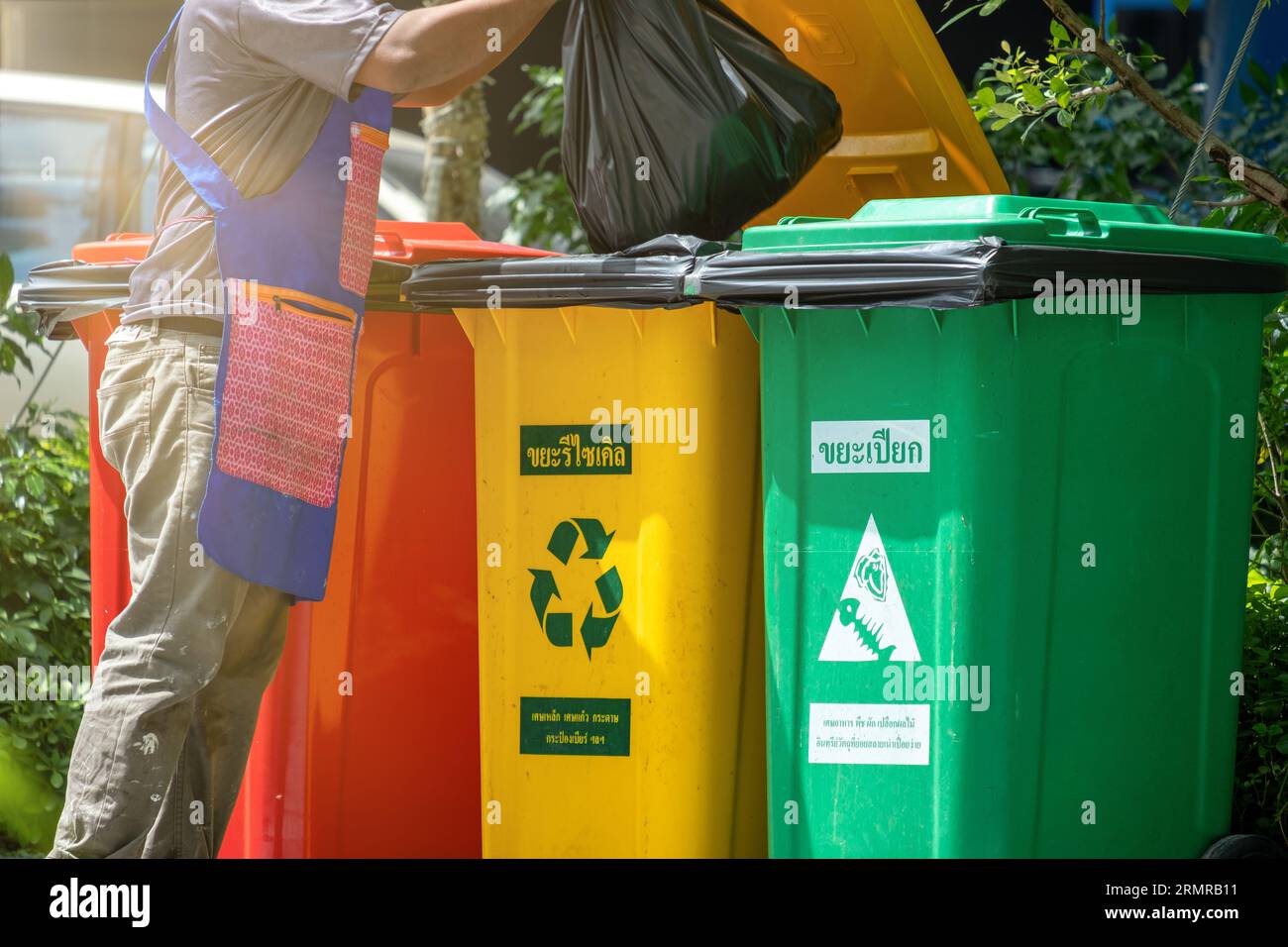 People throwing some garbage into a recycle bin. Recycling concept by